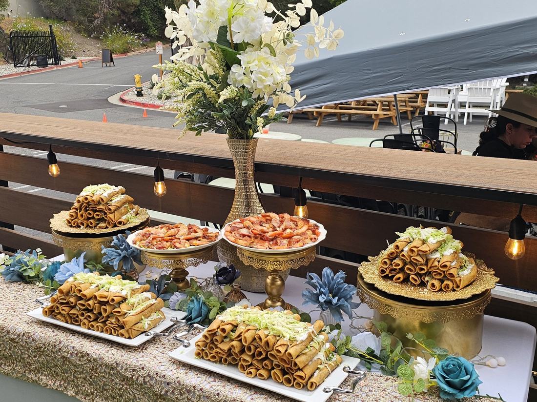Taquitos and bacon-wrapped shrimp appetizer station styled with string lights