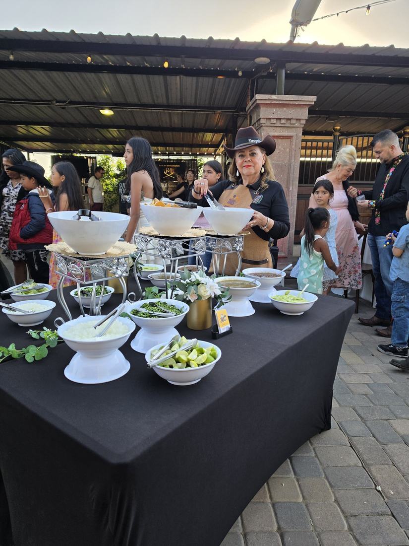 Tacos Don Jorge staff serving the salsa and toppings bar