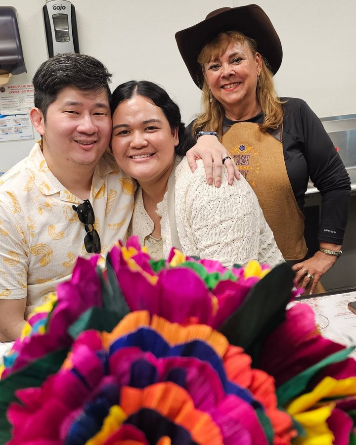 Lupita celebrating with a couple in the Tacos Don Jorge kitchen