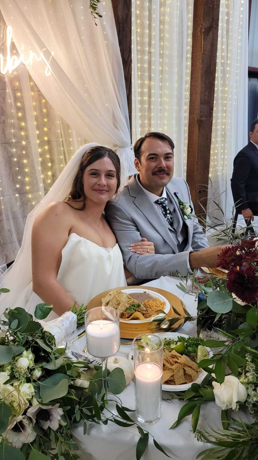 Bride enjoying a taco plate surrounded by white roses