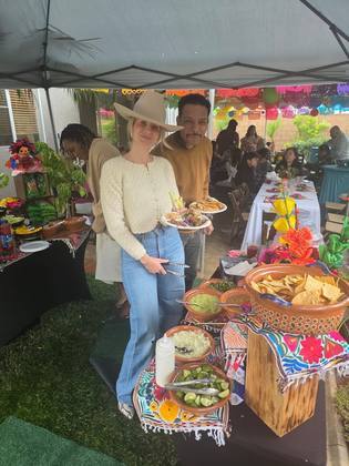 Guests enjoying plates at a Taco Festival station under papel picado