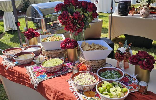 Salsa bar decorated with fresh roses at a Taco Festival event